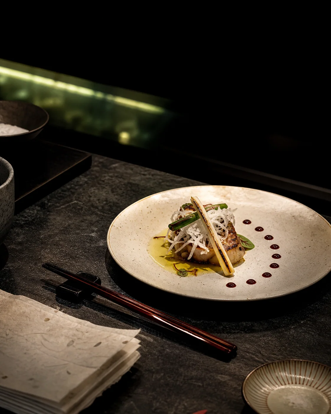 UMAMI: сервировка блюда на тёмной станции с керамикой и палочками